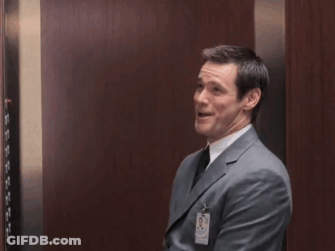 Man In Suit Raising Fists In Elevator GIF
