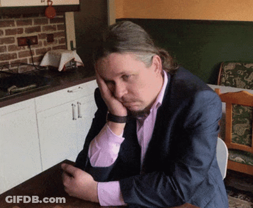 Man In Suit Resting Head On Hands GIF