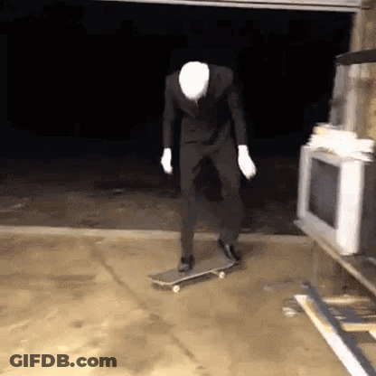 Man In Suit Riding Skateboard In Garage GIF