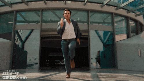 Man In Suit Running Past Mission Impossible Building GIF