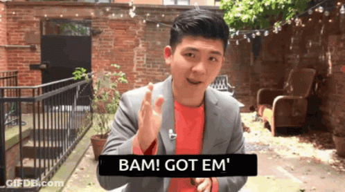 Man In Suit Saying Bam Got Em In Front Of Brick Wall GIF