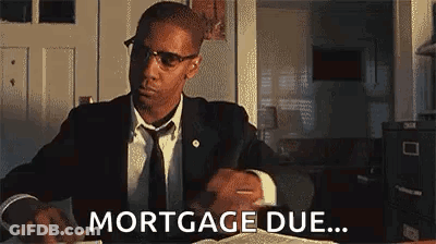 Man In Suit Saying Mortgage Due At Desk With Book GIF