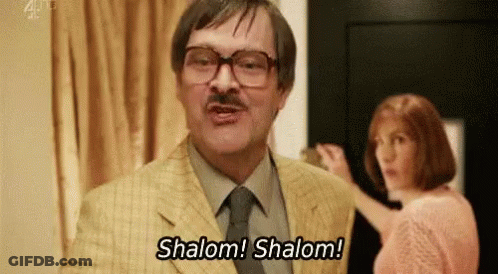 Man In Suit Saying Shalom Shalom With Woman Behind GIF