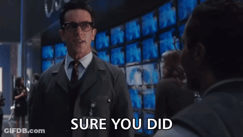 Man In Suit Saying Sure You Did In Front Of Monitors GIF