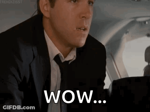 Man In Suit Saying Wow In Airplane GIF