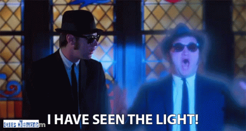 Man In Suit Says I Have Seen The Light In Front Of Stained Glass Window GIF
