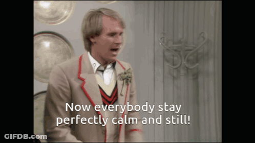 Man In Suit Says Now Everybody Stay Perfectly Calm And Still GIF