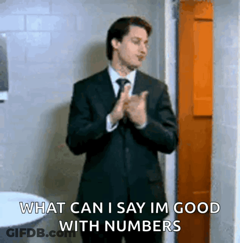 Man In Suit Says What Can I Say Im Good With Numbers In Bathroom GIF