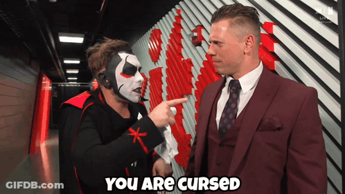 Man In Suit Says You Are Cursed To Masked Man GIF