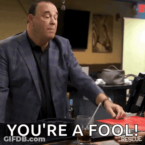 Man In Suit Says You're A Fool Holding Glass GIF