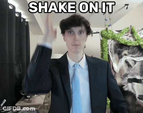 Man In Suit Shaking Hand In Front Of Shake Sign GIF