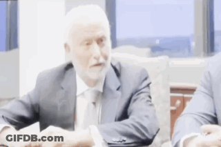 Man In Suit Shaking Hands At Table GIF