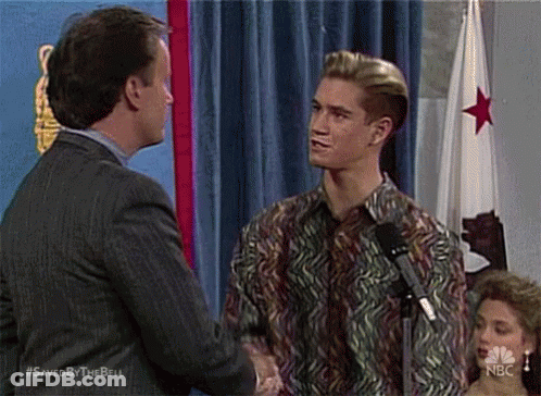 Man In Suit Shaking Hands With Man In Colorful Shirt GIF