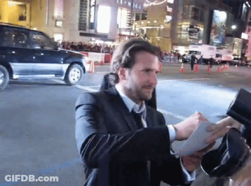 Man In Suit Signing Autographs For Fans GIF