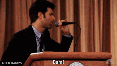Man In Suit Singing Into Microphone At Podium GIF