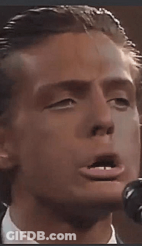 Man In Suit Singing Into Microphone Making Funny Face GIF