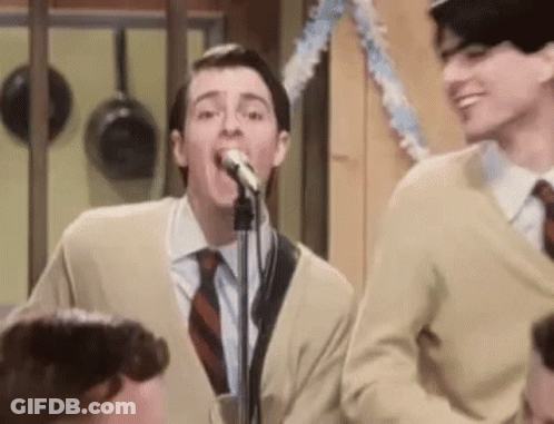 Man In Suit Singing Into Microphone Next To Another Man GIF