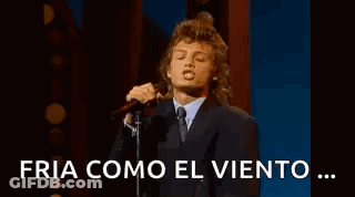 Man In Suit Singing Into Microphone On Stage GIF