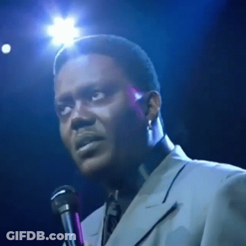 Man In Suit Singing Into Microphone On Stage GIF