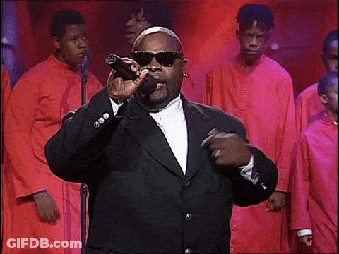 Man In Suit Singing Into Microphone With Choir GIF