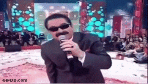 Man In Suit Singing Into Microphone With Sunglasses GIF