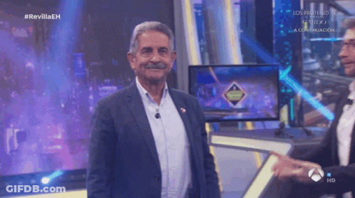 Man In Suit Singing On Stage With Green Background GIF