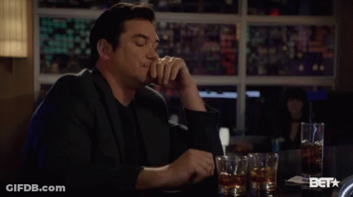 Man In Suit Sitting At Bar With Whiskey GIF