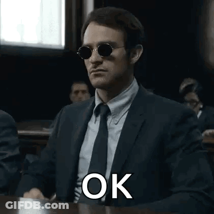 Man In Suit Sitting At Courtroom Table GIF