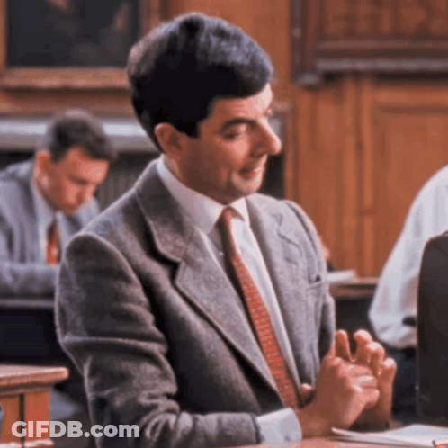 Man In Suit Sitting At Desk GIF