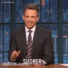 Man In Suit Sitting At Desk Saying Sucker GIF