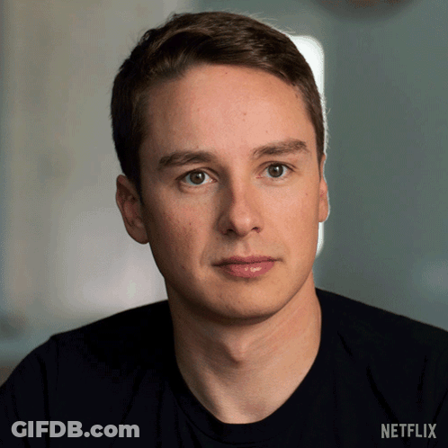 Man In Suit Sitting At Desk Saying What That Means GIF