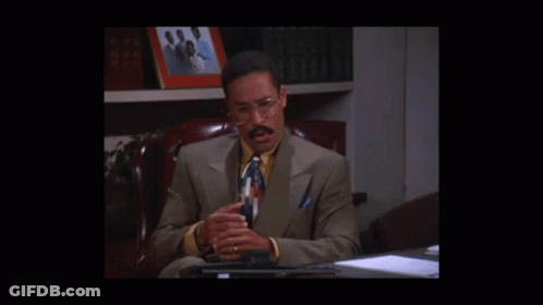 Man In Suit Sitting At Desk Talking GIF