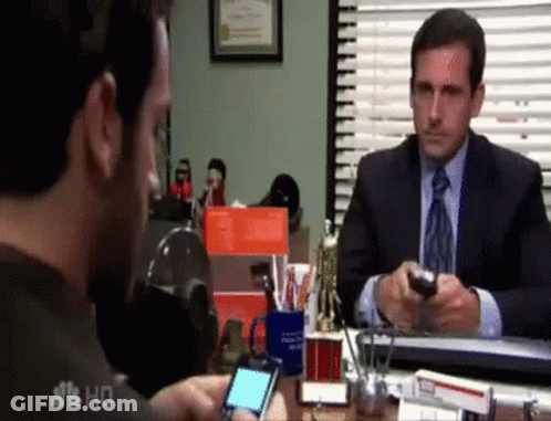 Man In Suit Sitting At Desk Talking On Cell Phone GIF
