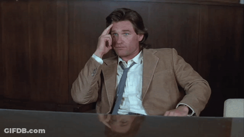 Man In Suit Sitting At Desk With Hand On Forehead GIF