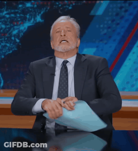 Man In Suit Sitting At Desk With Hands On Head GIF
