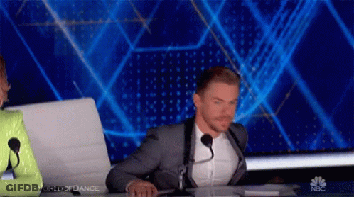 Man In Suit Sitting At Desk With Microphone GIF