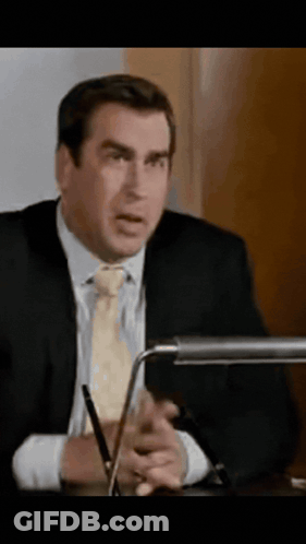Man In Suit Sitting At Desk With Pen GIF