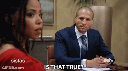 Man In Suit Sitting At Desk With Woman Behind Him Saying Is That True GIF