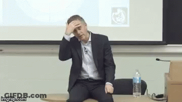 Man In Suit Sitting At Projector Screen GIF