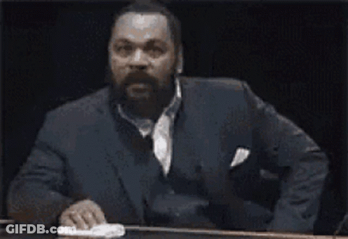 Man In Suit Sitting At Table Says Ah Bon GIF