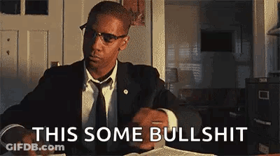 Man In Suit Sitting At Table With Book And Cell Phone GIF