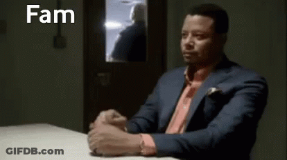 Man In Suit Sitting At Table With Hands Folded GIF