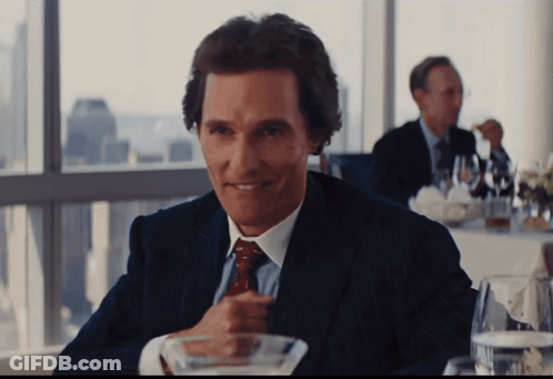 Man In Suit Sitting At Table With Martini GIF