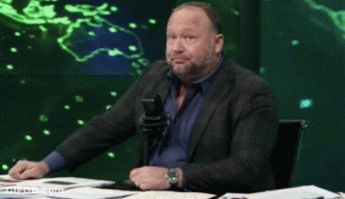 Man In Suit Sitting At Table With Microphone GIF