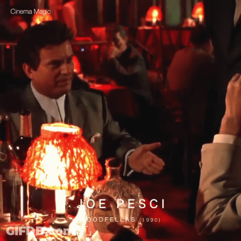 Man In Suit Sitting At Table With Red Lamp Joe Pesci GIF
