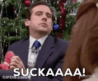 Man In Suit Sitting By Christmas Tree Saying Suckaaa GIF