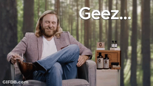 Man In Suit Sitting Cross-Legged Saying Geez GIF