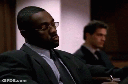 Man In Suit Sitting In Courtroom With Another Man GIF