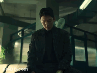 Man In Suit Sitting In Dark Room GIF