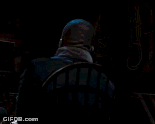 Man In Suit Sitting In Dark Room GIF